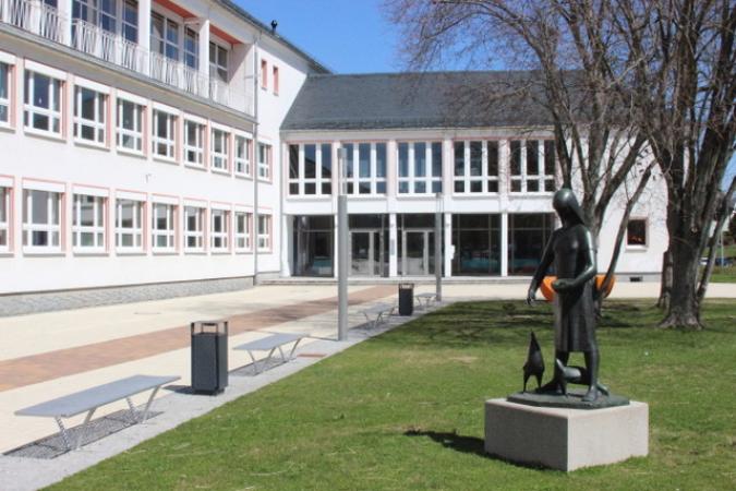 Haupteingang der Schule mit Statue
